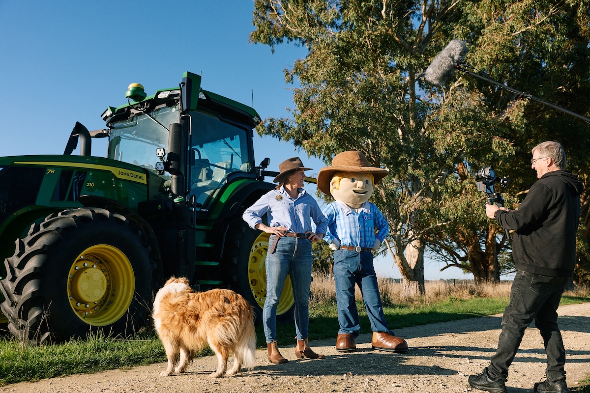 A news crew filming the two George the Farmer team members with a dog